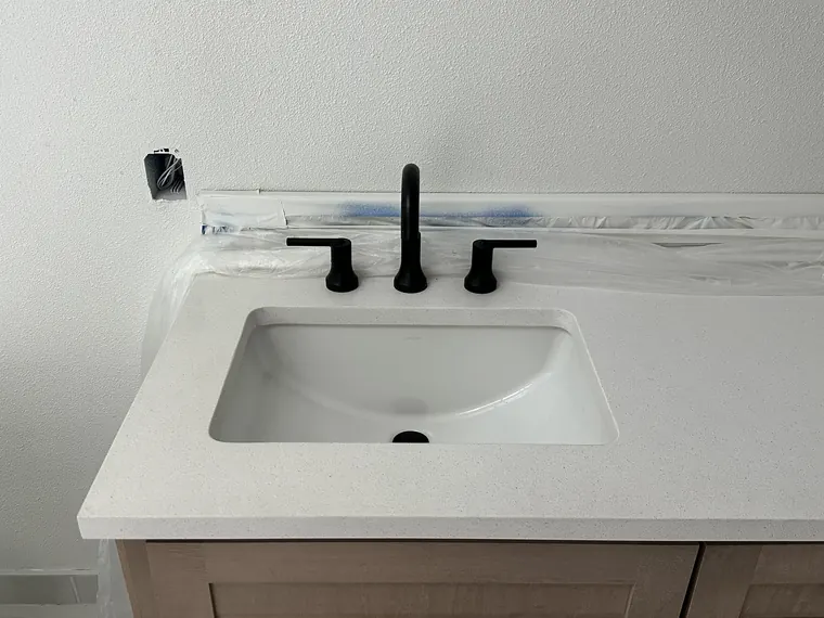 New undermount vanity sink and matte black widespread faucet set in a quartz countertop in Hillsboro, Oregon