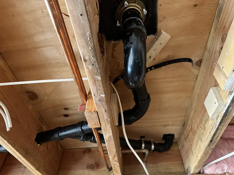 New ABS drain line and copper water piping installed between floor joists in a crawlspace in Hillsboro, Oregon