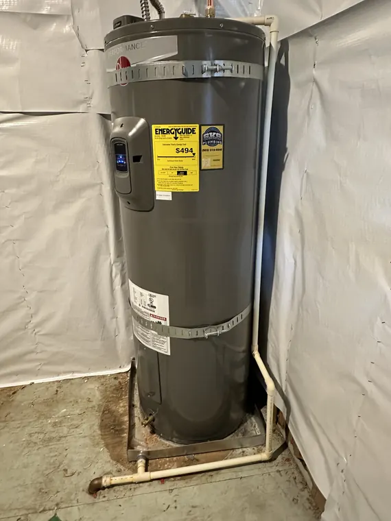 New electric water heater set on a stand with protective sheeting during a replacement in Hillsboro, Oregon