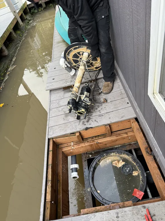SKS Plumbing technician pumping standing water and servicing a crawlspace sump during a flooding emergency in Hillsboro, Oregon