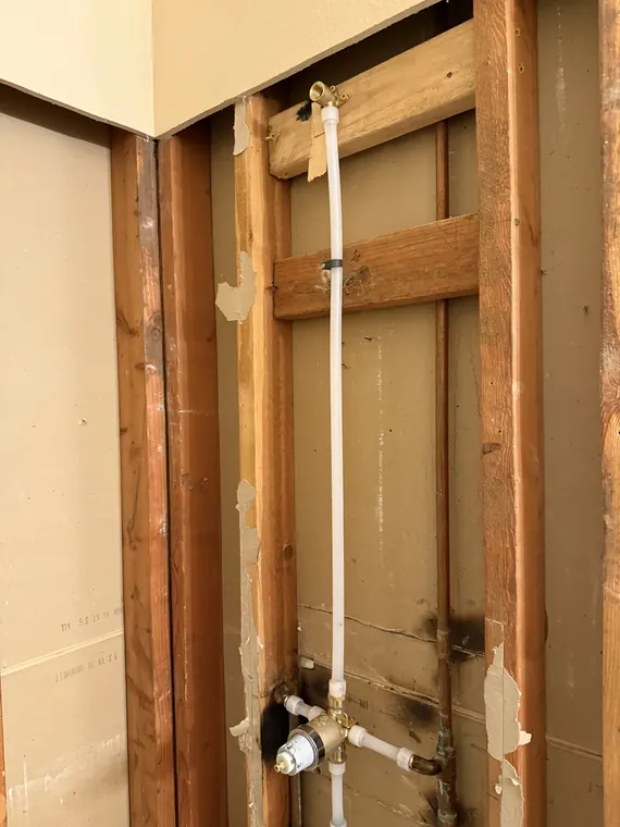 New PEX hot and cold water lines roughed into an open stud wall for a laundry room in Hillsboro, Oregon