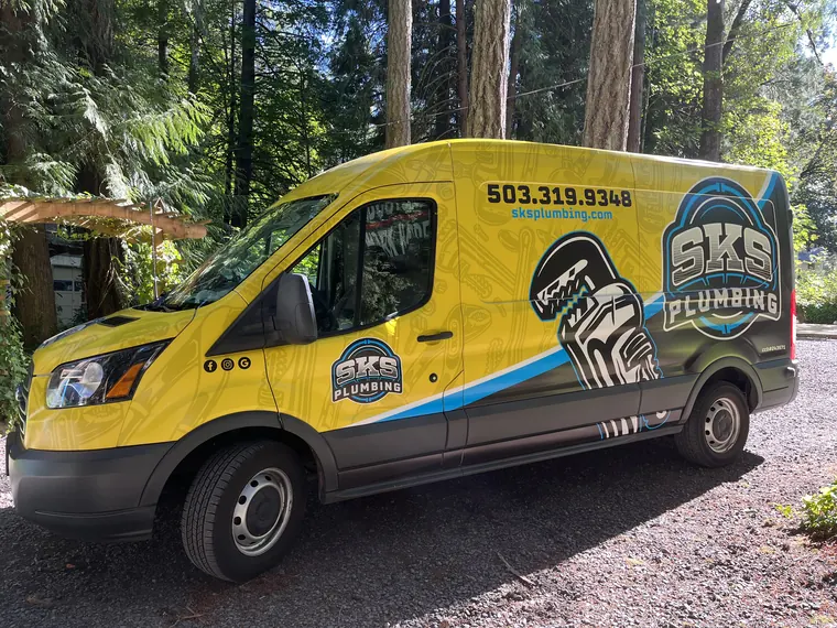 Side view of the branded SKS Plumbing service van showing the company phone number in Hillsboro, Oregon