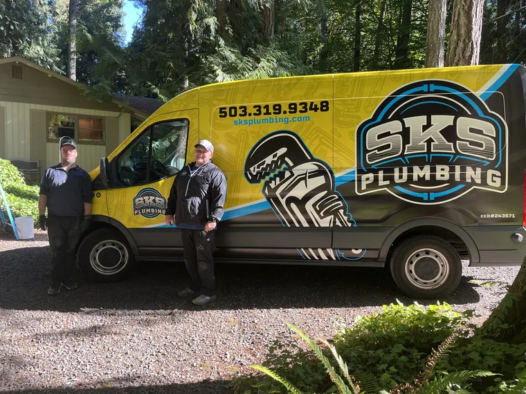 SKS Plumbing technicians in uniform beside the company service van on a job in Hillsboro, Oregon