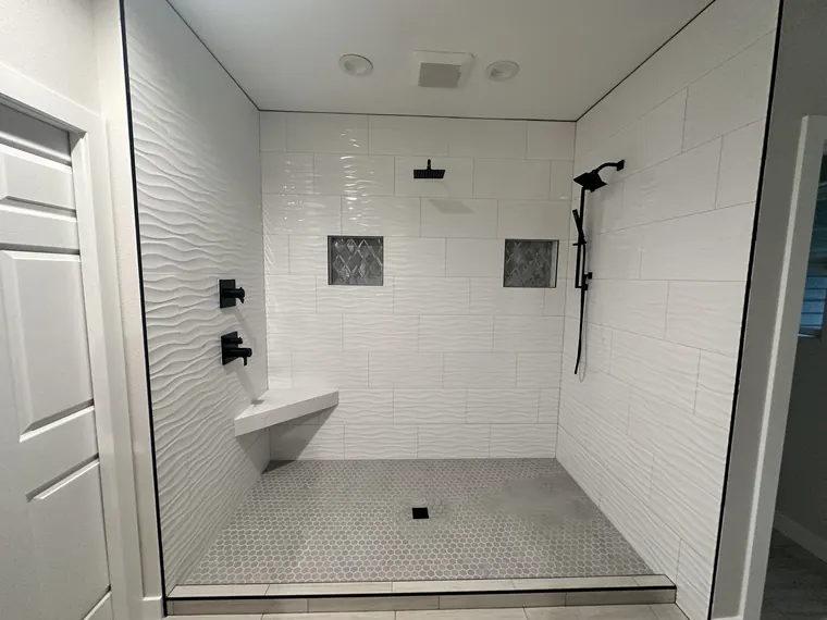 Finished walk-in shower with white subway tile, a built-in bench, and matte black fixtures in a Hillsboro, Oregon bathroom remodel