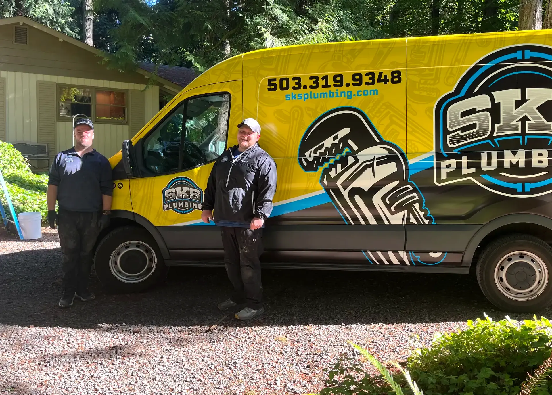SKS Plumbing LLC plumbers standing beside their branded yellow service van in Hillsboro, Oregon